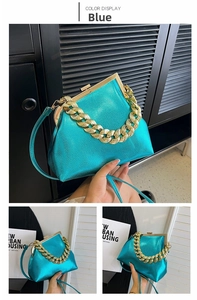 Detail of metallic blue leather handbag with gold chunky chain and clasp closure