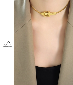 Gros plan d'un collier en acier inoxydable doré avec fermoir à boucle vintage sur mannequin