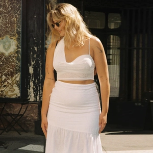 Detail of white one-shoulder crop top and ruffled mermaid skirt with fabric texture