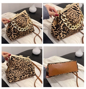 Detail view of leopard print shell bag with gold chain strap and interior storage