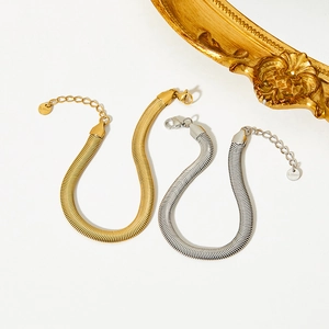 Flat lay of gold and silver stainless steel snake chain bracelets with lobster clasps
