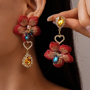 Boucles d'oreilles vintage fleurs rouges brodées avec cristaux sur un modèle