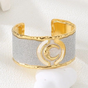 Macro shot of gold cuff bracelet featuring hammered texture and a crescent moon relief