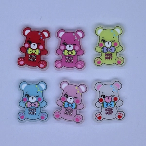 Flat lay of colorful resin cartoon bears with HUG ME text for DIY phone case accessories