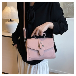 Pink PU leather handbag with metallic lock shown on model for elegant styling