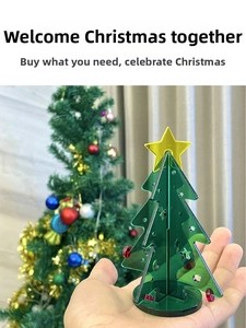 Close-up of a green acrylic mini Christmas tree with a yellow star on a black base