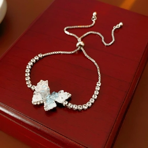 Gros plan du bracelet papillon avec cristaux bleus et perles sur support bois
