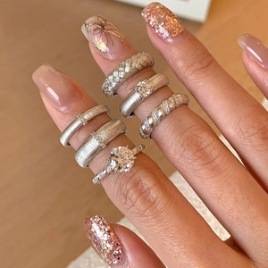 Stackable brushed silver rings with pearls and zircon stones shown on a model hand