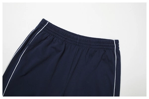 Détail macro du pantalon de sport bleu marine avec taille élastique et liseré blanc