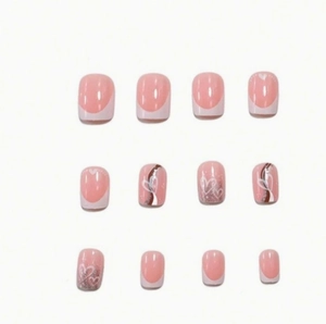Pink short square press-on nails with white French tips, silver glitter, and heart patterns
