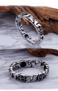 Detail of vintage steel link chain bracelet with cross anchor badge and matte finish