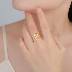 Detailed close-up of a golden interconnected Celtic knot ring worn on a finger