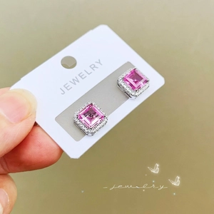 Detailed macro view of silver square pink ruby earrings with halo cubic zirconia stones