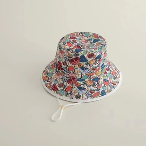 Close-up of kids sun hat with colorful mushroom and strawberry patterns and chin strap