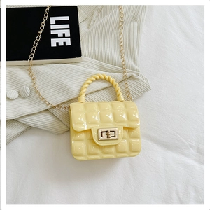 Detailed close-up of yellow quilted jelly bag with gold chain and twist handle