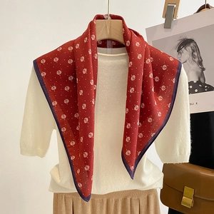 Detail of red floral silk scarf with white leaf patterns and dark purple rolled hem edge