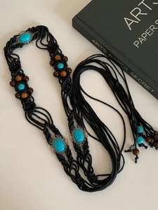 Detail of bohemian waist chain with turquoise stones, wood beads and braided rope