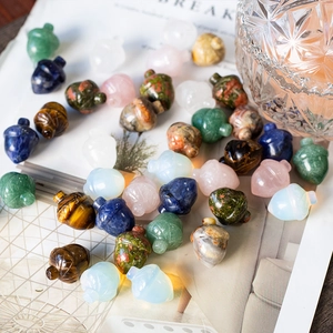 Detail of colorful crystal acorn pendants with jade and gemstone textures on a desk