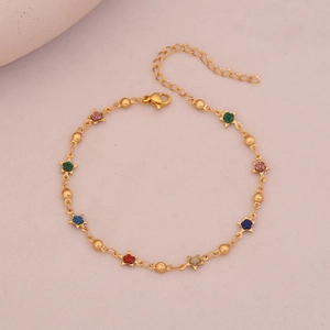 Macro detail of gold plated anklet with colorful star pendants and polished beads