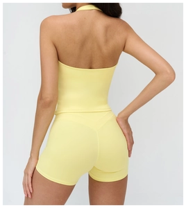Detail view of the back of a light yellow V-neck yoga vest and high-waist lifting shorts