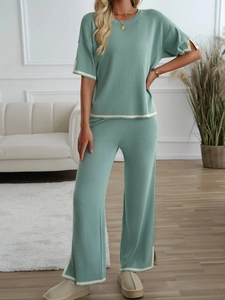 Detail showing light green knit set with cream striped cuffs on the top and wide-leg pants