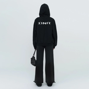 Detail view of black cotton wide-leg trackpants with white DNA print on the back
