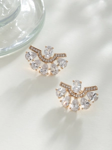 Detailed macro view of fan-shaped gold-plated stud earrings with zircon and pearls