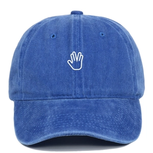 Detail of palm gesture white embroidery on washed blue denim cotton baseball cap