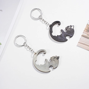 Detail of interlocking cat-shaped keychains in black glitter and grey wood grain finish