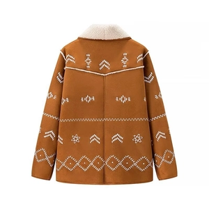 Detail of white floral embroidery on back of brown suede jacket with shearling collar