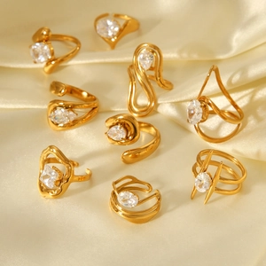 Close-up of golden zircon rings on silk background with polished metal textures