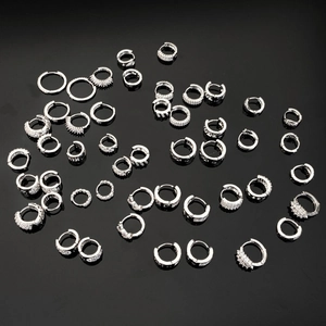 Detailed collection of silver earrings with sparkling cubic zirconia on a black mirror