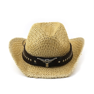 Detail of straw cowboy hat with leather band and metal bull head pendant on white background