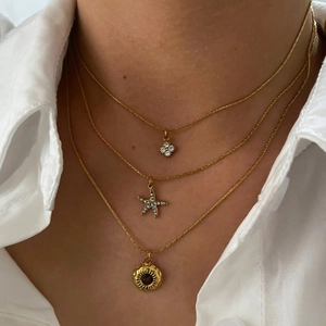 Three-layer gold necklace set featuring starfish charms and a textured sun coin pendant