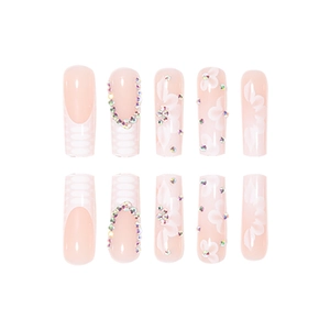 Pink press-on nail set with white floral patterns and rhinestones in long coffin shape