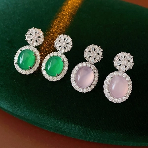 Détail de boucles d'oreilles vintage avec zircon et calcédoine sur velours vert foncé