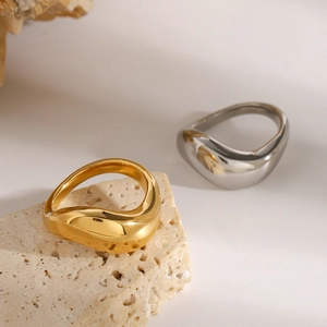 Dettaglio di anelli lava color oro e argento su un piedistallo in pietra testurizzata