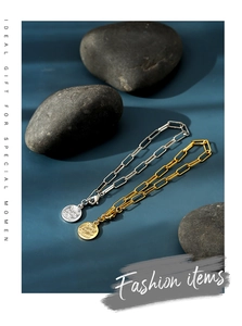 Detail of gold and silver paperclip link bracelets with round charms on blue backdrop