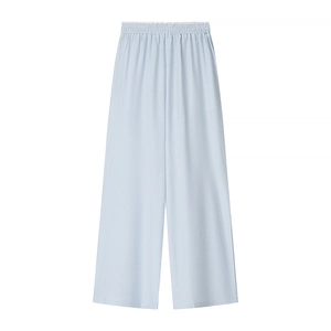 Detail of light blue pleated wide-leg trousers with elastic waistband on white background