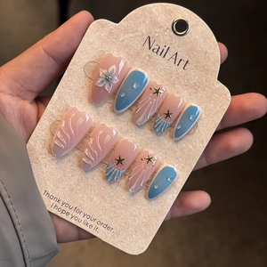 Detail of 3D embossed floral nail art with gold stars and seashell texture on hand