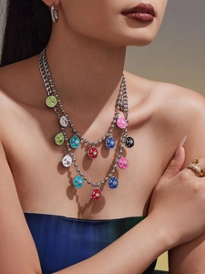 Close-up of layered stainless steel chain necklace with colorful star moon charms