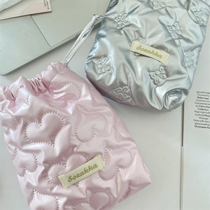 Detail of pink heart and silver bow quilted drawstring pouches with glossy metallic finish