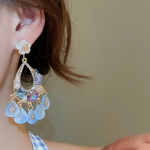 Detail of luxury floral tassel earrings with rhinestones, pearls and blue crystals