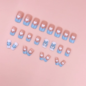 Sweet pink and blue press-on nails with cute heart patterns and cartoon bear designs