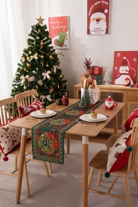 Close-up of Christmas table runner with festive wreath pattern and matching pillow case