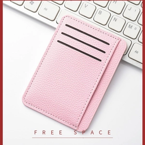 Slim pink lychee leather card holder for women with multi-slot design on a modern desk