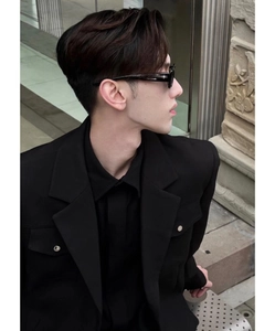 Detail of square black sunglasses with meteor accents and metal button jacket sleeves