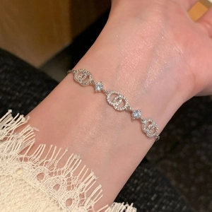 Detail view of double interlocking rings bracelet with sparkling stones on woman's wrist
