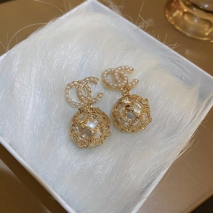 Detailansicht der goldenen Ohrringe mit Perlen-Doppel-C-Logo und hohlem Kugelanhänger
