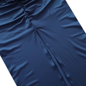 Detailed close-up of dark blue skirt featuring side slit design and ruched fabric texture